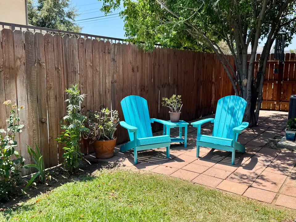 Adirondack chairs in the fenced backyard
