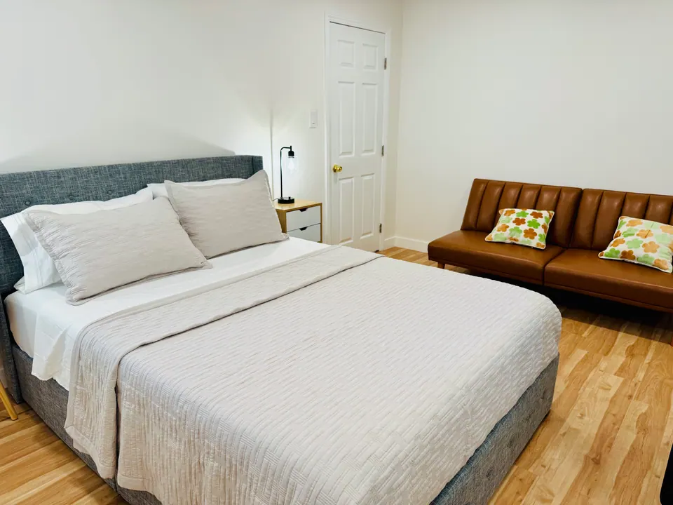 Bedroom 1 with queen bed and leather sofa