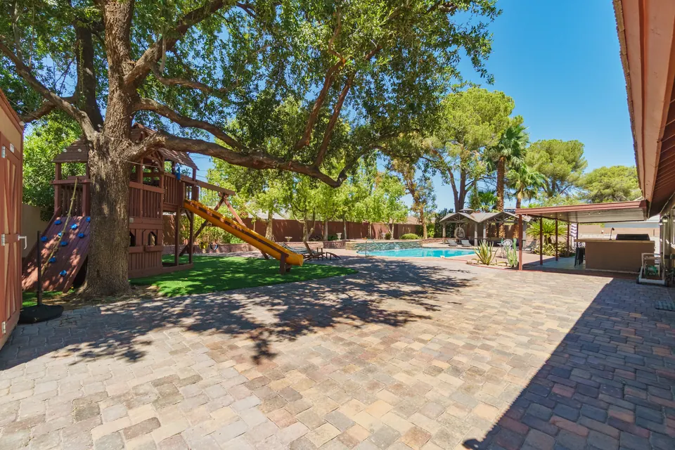 Shaded backyard with play area and pool