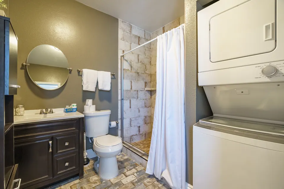 Bathroom with shower and stacked washer/dryer