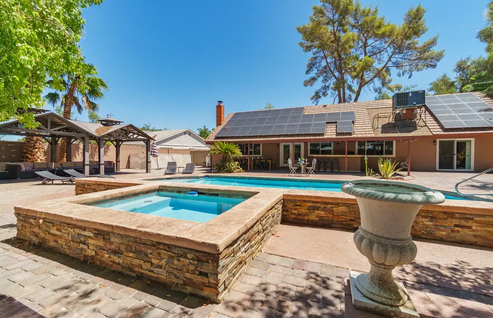 Raised spa beside the pool with the house behind
