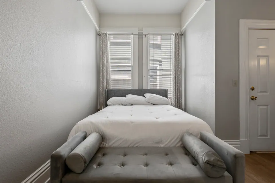 Queen bed beneath tall windows