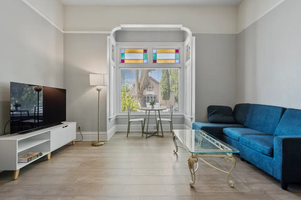 Living room with blue sofa and stained-glass bay window